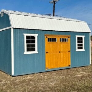 Front exterior view of a blue lofted barn-style portable shed with white trim, yellow double doors, and two front windows