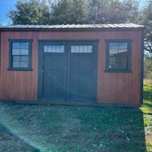 Front exterior view of an A-frame style portable shed with wood siding, double doors, and two front windows