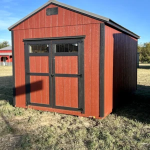 Red barn-style portable shed with wood siding, black trim, and double doors with windows