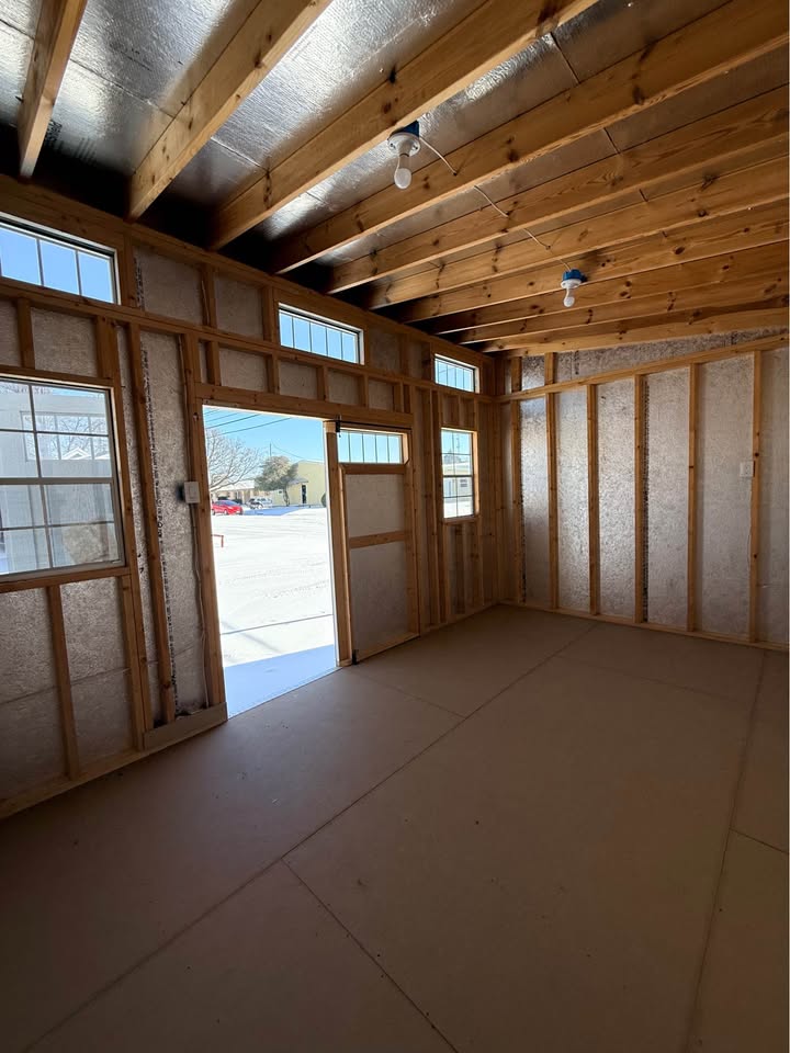Spacious 10x16 Modern Shed interior in Bowie TX featuring high walls, multiple windows, double doors and electrical package
